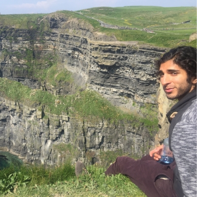 student sitting on cliffside