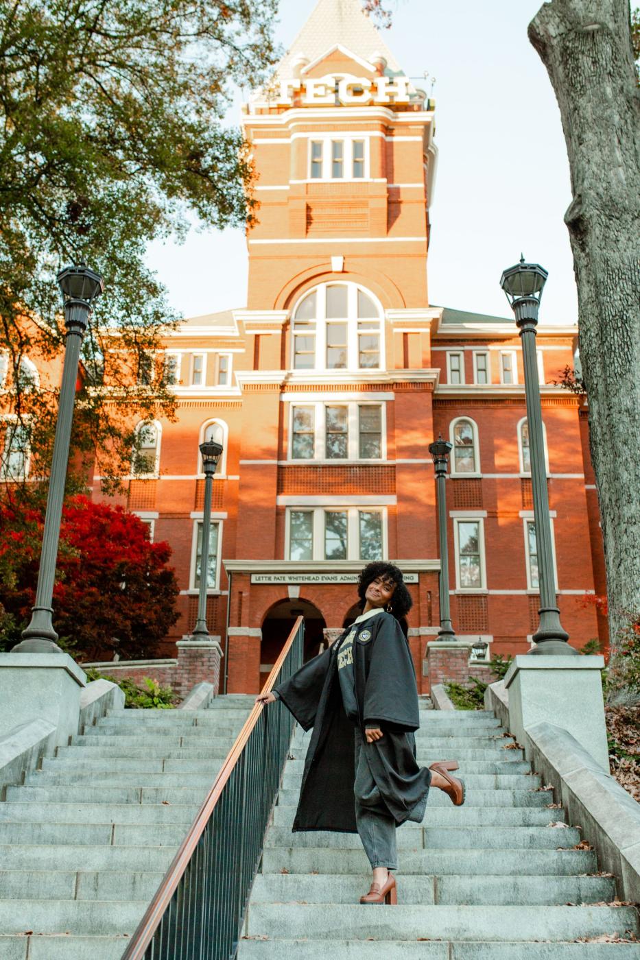 Sinet Adous poses in front of Tech Tower in graduation regalia.